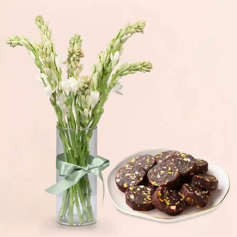 Dry Fruit Dates Roll from Shree Mithai with Rajnigandha Stems in a Glass Vase