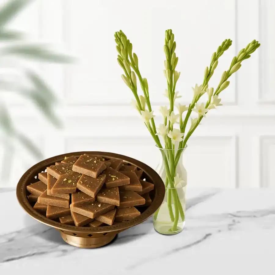 Karupatti Katli from Sri Krishna Sweets with a Rajnigandha Stems in a Glass Vase